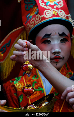 Bangkok, Thailand  11th February 2013. lucky Chinese decoration being held in front of traditional Chinese opera performer,  Chinese new year festival, year of the snake, Bangkok, Thailand Credit:  Kraig Lieb / Alamy Live News Stock Photo