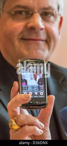 Diocesan administrator Auxillary Bishop Reinhard Hauke holds his mobile phone with a picture of him with Pope Benedict XVI and Bishop Wanke in Erfurt, Germany, 11 February 2013. He spoke about the resignation of Pope Benedict XVI. Photo: Michael Reichel Stock Photo