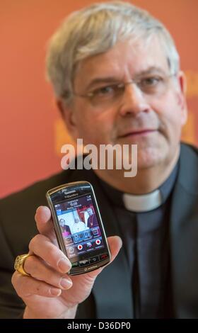 Diocesan administrator Auxillary Bishop Reinhard Hauke holds his mobile phone with a picture of him with Pope Benedict XVI and Bishop Wanke in Erfurt, Germany, 11 February 2013. He made a statement about the resignation of Pope Benedict XVI. Photo: Michael Reichel Stock Photo