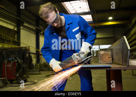 A construction worker using an angle grinder producing a lot of sparks Stock Photo