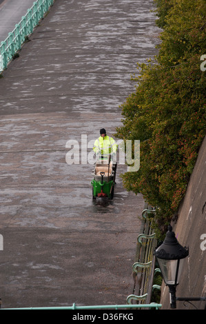 Brighton and Hove City Council worker cleaning the mid level promenade walk along the seafront UK Stock Photo