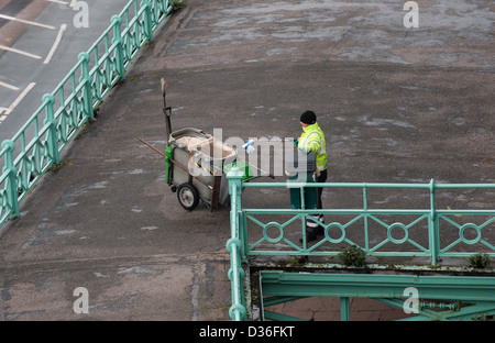 Brighton and Hove City Council worker cleaning the mid level promenade walk along the seafront UK Stock Photo