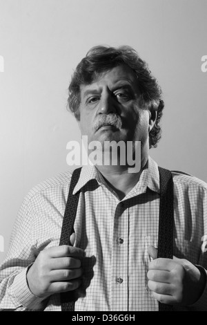 middle-aged man in a light shirt and suspenders, black and white  Stock Photo