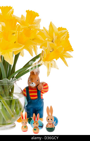 A large and some small decorative Easter bunnies under a bouquet of daffodils against white background Stock Photo