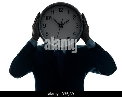 one  businessman holding clock in silhouette studio isolated on white background Stock Photo