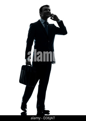 one  businessman walking on the telephone in silhouette studio isolated on white background Stock Photo