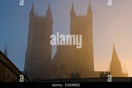 Grade 1 listed Lincoln Cathedral west front in sunlit morning mist fog Lincolnshire England Europe Stock Photo