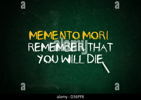 Memento mori, remeber that you will day. Latin quote handwritten with chalk on a green school board. Stock Photo