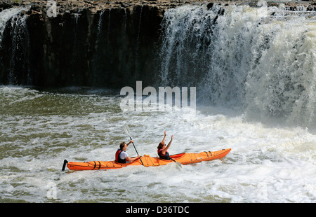 Couple in kayak paddle up close to Haruru Falls in Waitangi. Stock Photo
