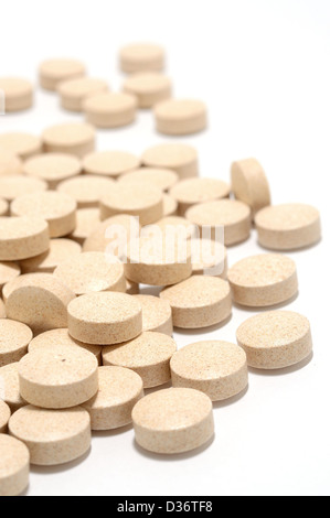 Macro shot of brown tablets on a white background. Stock Photo