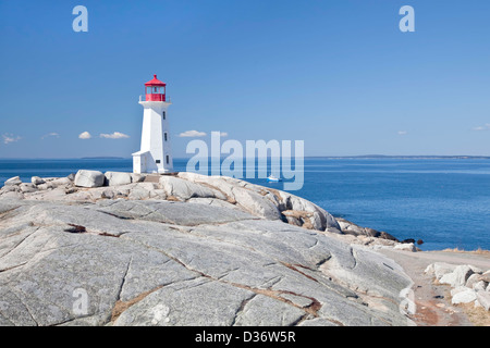 Peggy's Cove lighthouse, Nova Scotia, Canada. Lobster boat gathering traps in the background. Stock Photo