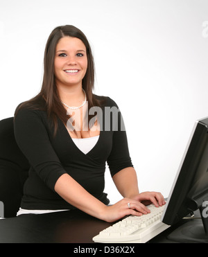 A cheerful young woman working on her computer. Stock Photo