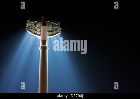 A back view from below of a huge bank of stadium lights on a single pole with their floodlights beaming down. See veritcal also. Stock Photo