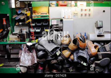 Pile of shoes awaiting repair in a cobblers shop, Wales. Stock Photo