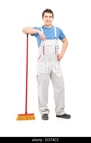 Full length portrait of a male cleaner holding a broom isolated on white background Stock Photo