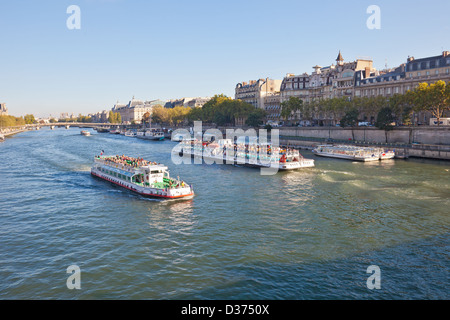 Tourists on two sightseeing boats Bateaux Mouches and Vedettes de Pont Neuf on the River Seine in central Paris. Stock Photo