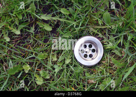 metallic sink hole among green grass background Stock Photo