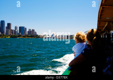 A woman and young child view the Sydney skyline from a boat on a sunny day from on board the Sydney Ferry as it approaches Manly. Stock Photo