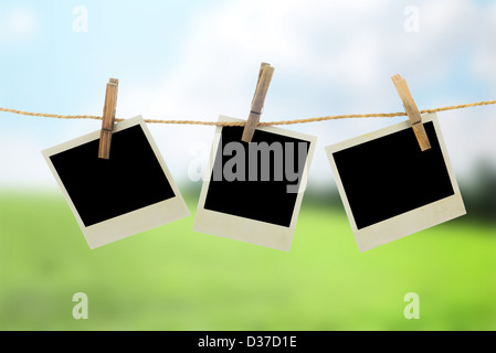 Three blank instant photos hanging on the clothesline Stock Photo