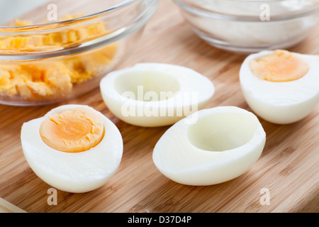 Two hard boiled eggs cut in half with yolk in bowl. Stock Photo