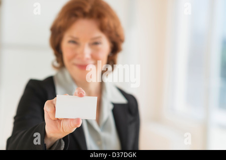 USA, New Jersey, Jersey City, Portrait of businesswoman holding blank business card Stock Photo