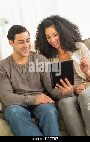 USA, New Jersey, Jersey City, Couple using digital tablet on sofa Stock Photo