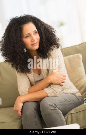USA, New Jersey, Jersey City, Portrait of mid adult woman sitting on sofa Stock Photo