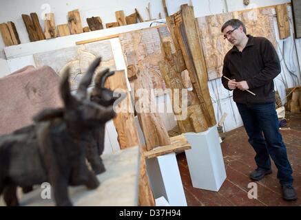 Sculptor Hans-Georg Wagner stands among his wooden artworks in his atelier in Cottbus, Germany, 28 January 2013. Photo: Patrick Pleul Stock Photo