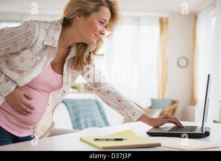 Pregnant woman using laptop Stock Photo
