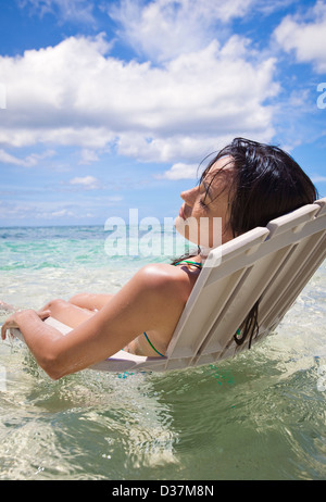 Woman in lawn chair in tropical water Stock Photo