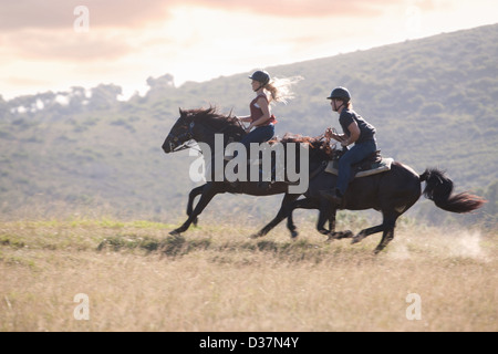 Couple riding horses in rural landscape Stock Photo