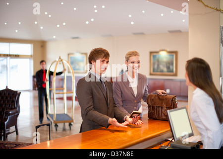 Businesswoman checking in to hotel Stock Photo