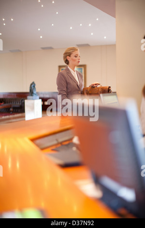 Businesswoman checking into hotel Stock Photo