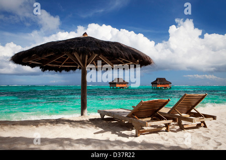 Chairs and umbrella on tropical beach Stock Photo