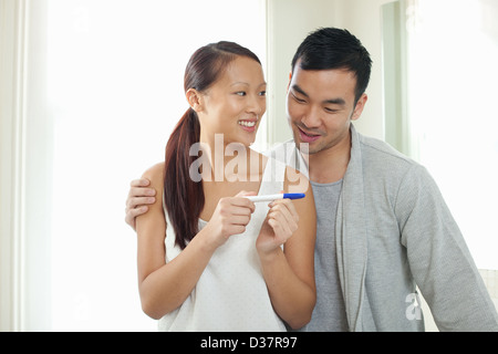 Couple taking pregnancy test in bathroom Stock Photo