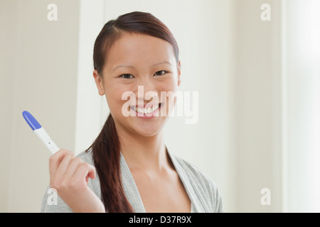 Woman taking pregnancy test in bathroom Stock Photo