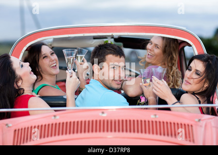 Friends toasting in convertible Stock Photo