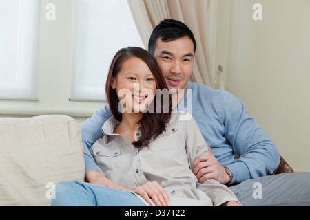 Smiling couple relaxing on sofa Stock Photo