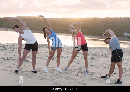 Runners stretching on beach Stock Photo