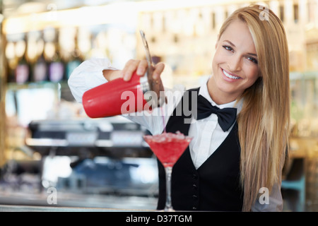 Denmark, Aarhus, Young female bartender pouring cocktail Stock Photo