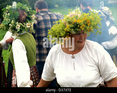 Latvians with summer wildflower wreath and National folklore costumes during Midsummer summer solstice celebration in Latvia, Baltic region, Europe. Stock Photo