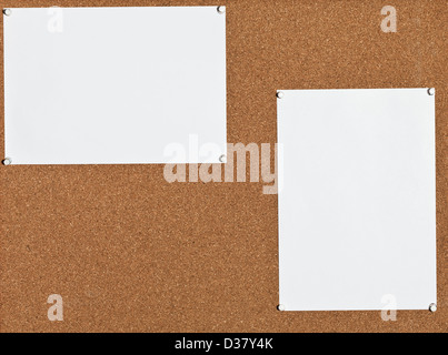 two blank white sheets of paper on cork board Stock Photo