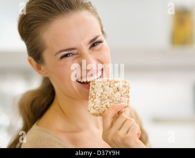 Happy young woman eating crisp bread Stock Photo