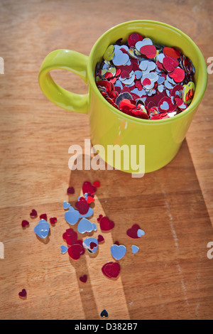 Creative still life of a mug full of love hearts. Stock Photo