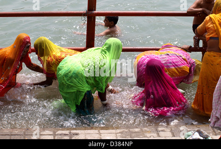Women bathing in the Ganges River at the third Shahi Snan Kumbh Mela in Har ki Pauri, Haridwar, India. Stock Photo