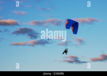 Motorized paraglider floats over the Homer Spit and Kachemak Bay at sunset, Homer, Alaska, USA Stock Photo
