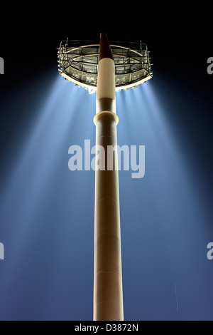 A back view from below of a huge bank of stadium lights on a single pole with their floodlights beaming down. Horizontal also. Stock Photo