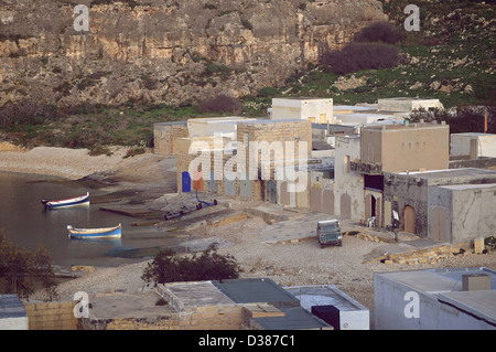 The unique inlet sea at Dwejra Gozo. A rocky beach with currents coming from a crack in the cliffs surrounded by boathouses. Stock Photo