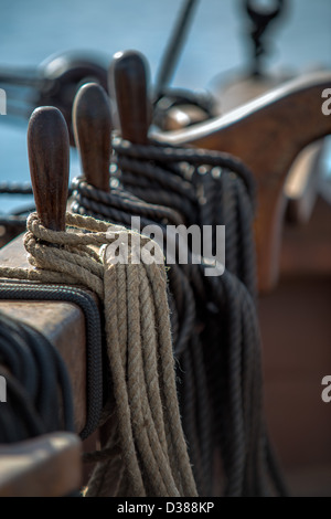 Selective focus of the belaying pins wound with rope on a 19th century tall sailing ship. Stock Photo