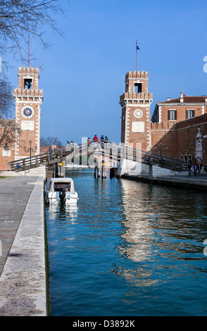 The twin towers at the entrance to the Arsenale reflected in the blue waters of one of Venice's canals. Stock Photo